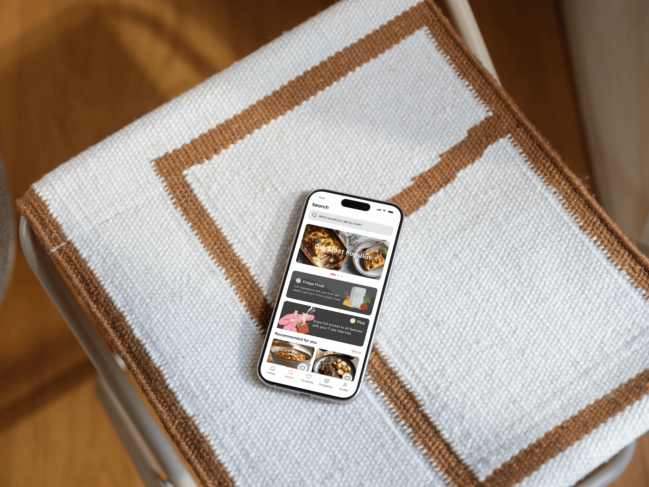 Dishcovery Search screen on a phone resting on a bordered woven cushion